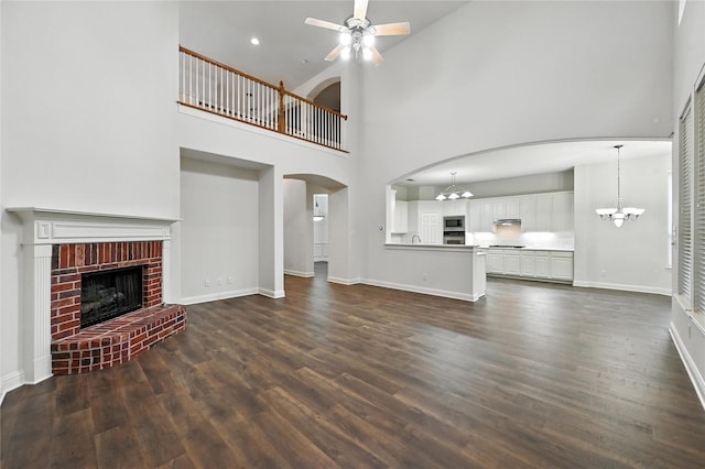 3816 Appleton Ln, Flower Mound, TX 75022 - unfurnished living room with a high ceiling, a ceiling fan, dark wood-type flooring, arched walkways, and a chandelier