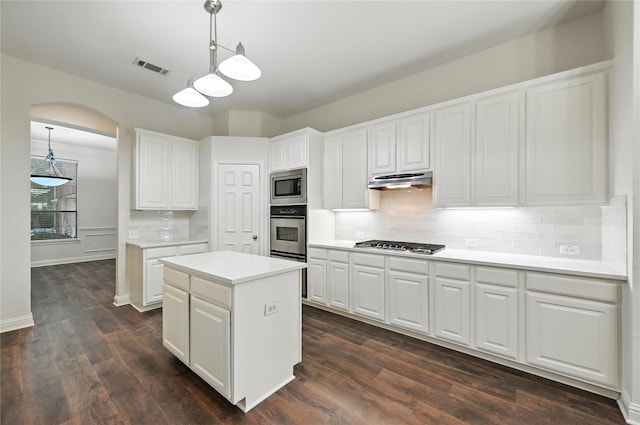 3816 Appleton Ln, Flower Mound, TX 75022 - kitchen featuring appliances with stainless steel finishes, a kitchen island, under cabinet range hood, white cabinets, and arched walkways