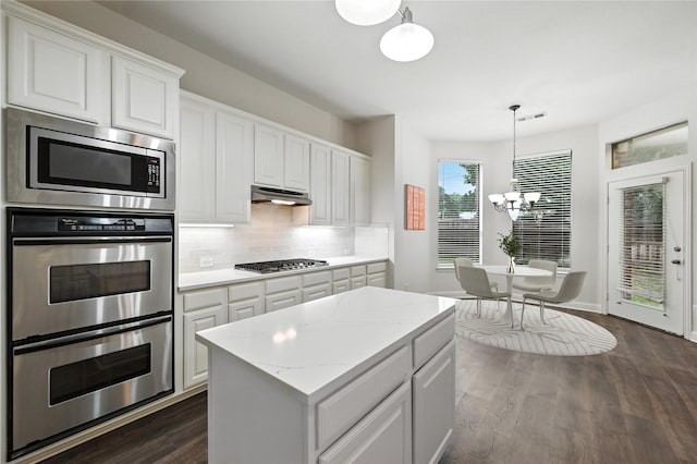 3816 Appleton Ln, Flower Mound, TX 75022 - kitchen featuring stainless steel appliances, a chandelier, decorative backsplash, white cabinetry, and dark wood-style floors