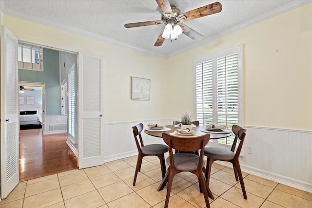 132 Cherrybark Dr, Coppell, TX 75019 - dining area featuring a ceiling fan, plenty of natural light, ornamental molding, wainscoting, and light tile patterned floors