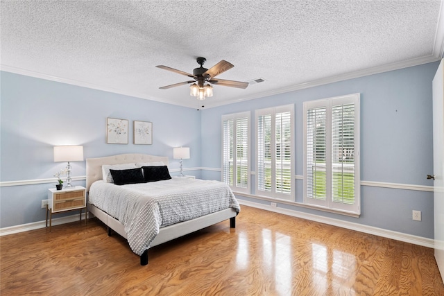 132 Cherrybark Dr, Coppell, TX 75019 - bedroom featuring wood finished floors, a textured ceiling, crown molding, baseboards, and a ceiling fan