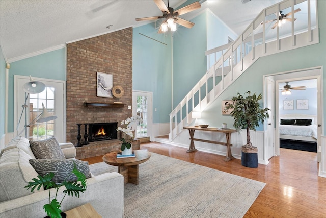 132 Cherrybark Dr, Coppell, TX 75019 - living area with a ceiling fan, wood finished floors, stairway, a fireplace, and high vaulted ceiling