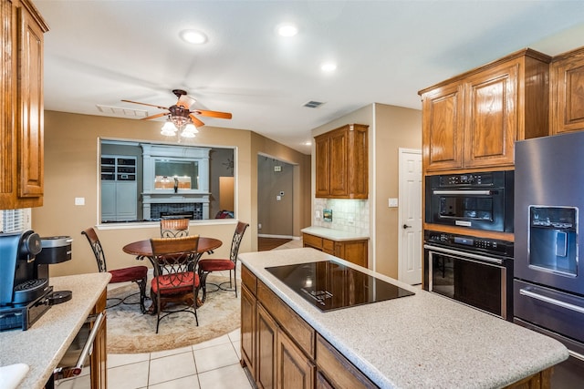 8017 Stonehill Dr, Plano, TX 75025 - kitchen with stainless steel fridge, black electric stovetop, brown cabinets, ceiling fan, and recessed lighting