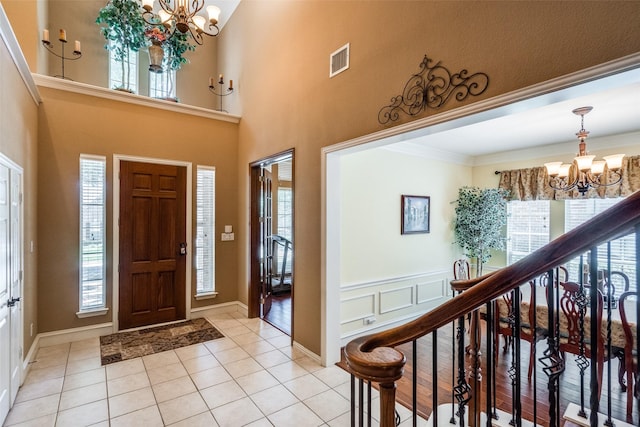 8017 Stonehill Dr, Plano, TX 75025 - foyer entrance featuring a chandelier, light tile patterned flooring, and ornamental molding