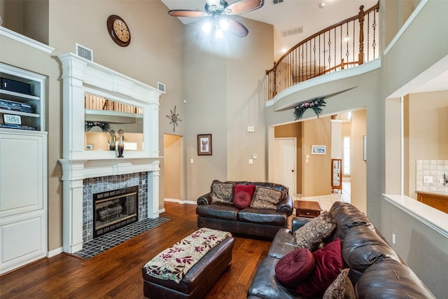 8017 Stonehill Dr, Plano, TX 75025 - living room with a towering ceiling, ceiling fan, a tiled fireplace, and wood finished floors
