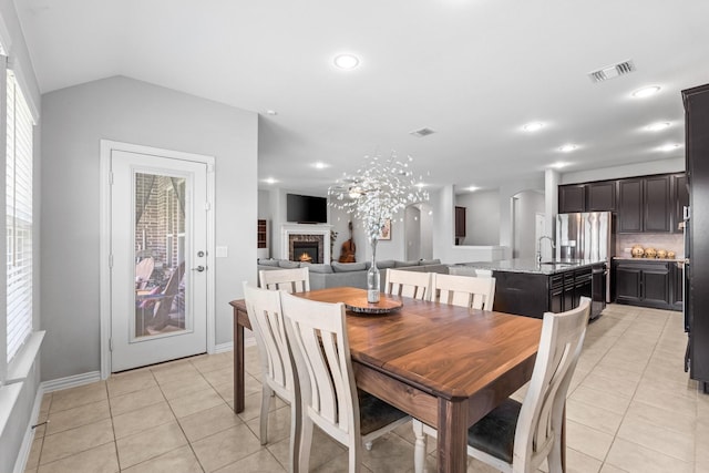 952 Sweeping Butte Dr, Fort Worth, TX 76052 - dining space with light tile patterned floors, a lit fireplace, baseboards, recessed lighting, and lofted ceiling