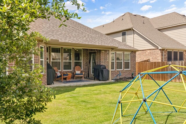 952 Sweeping Butte Dr, Fort Worth, TX 76052 - rear view of house with brick siding, a patio, a shingled roof, and a playground