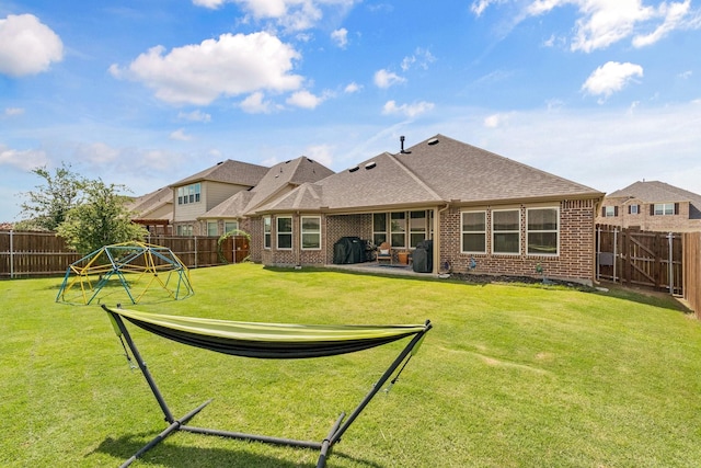 952 Sweeping Butte Dr, Fort Worth, TX 76052 - rear view of house with brick siding, a patio area, a shingled roof, and a playground
