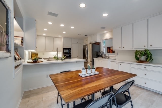 9616 Viewside Dr, Dallas, TX 75231 - kitchen with black appliances, light countertops, white cabinets, recessed lighting, and a peninsula