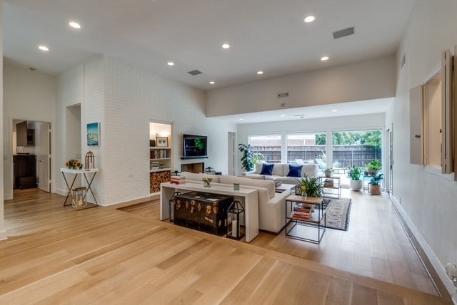 9616 Viewside Dr, Dallas, TX 75231 - living area featuring light wood-style flooring, a towering ceiling, and recessed lighting