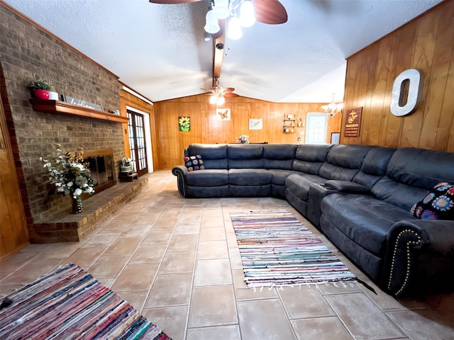 107 W Bayside Dr, Mabank, TX 75156 - tiled living area with ceiling fan, wood walls, vaulted ceiling, a fireplace, and a textured ceiling