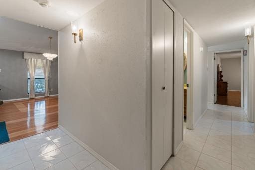 4028 Engleman St, Fort Worth, TX 76137 - hallway with light tile patterned flooring, baseboards, and a chandelier