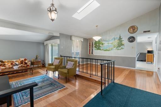 4028 Engleman St, Fort Worth, TX 76137 - living area featuring wood finished floors, vaulted ceiling, and a skylight