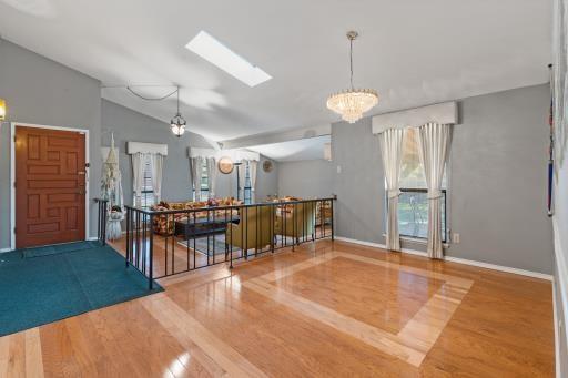 4028 Engleman St, Fort Worth, TX 76137 - kitchen with a chandelier, a skylight, wood finished floors, baseboards, and lofted ceiling