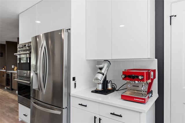 9918 Ila Dr, Dallas, TX 75220 - kitchen featuring stainless steel appliances, wine cooler, backsplash, and white cabinets