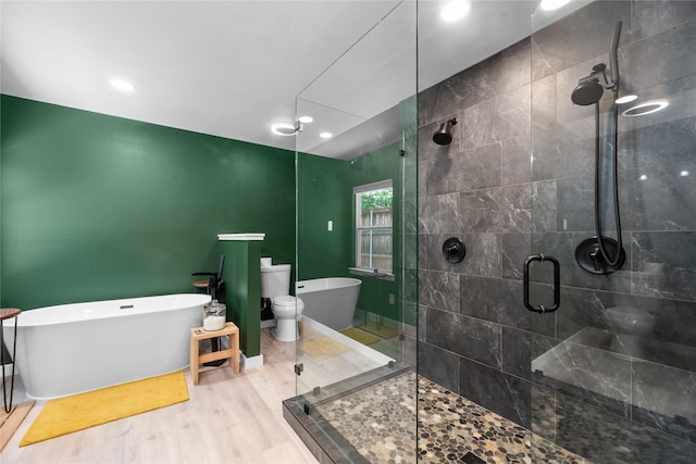9918 Ila Dr, Dallas, TX 75220 - full bathroom with toilet, a freestanding tub, a stall shower, recessed lighting, and wood finished floors
