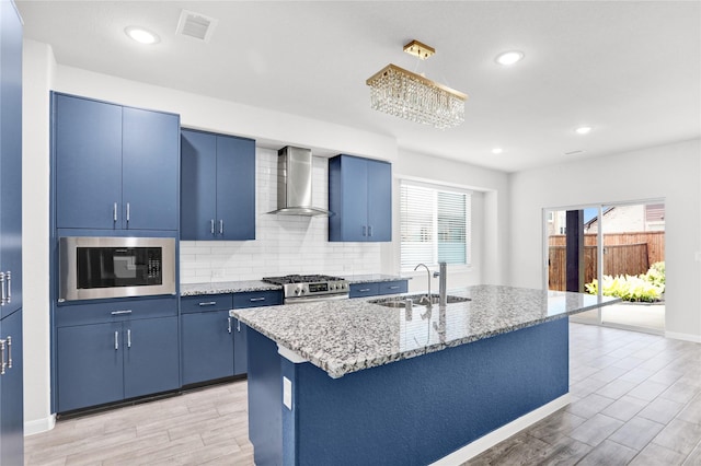 1135 Saddle Ridge Dr, Aubrey, TX 76227 - kitchen with a sink, wall chimney range hood, built in microwave, blue cabinets, and stainless steel gas range