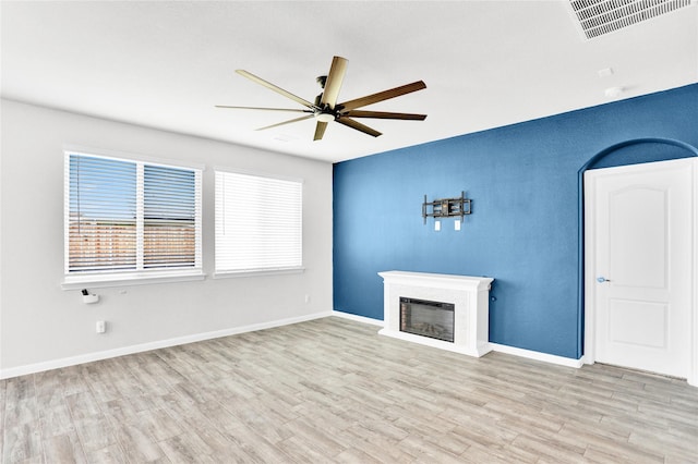 1135 Saddle Ridge Dr, Aubrey, TX 76227 - unfurnished living room featuring a ceiling fan, a glass covered fireplace, and wood finished floors