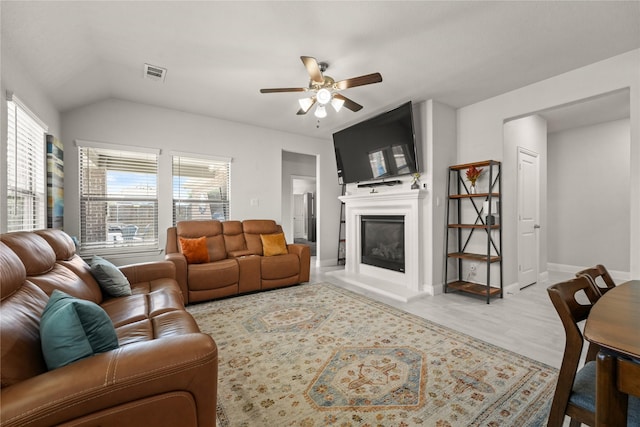 3409 Melrose Ct, Wylie, TX 75098 - living room featuring ceiling fan, a glass covered fireplace, light wood-style floors, baseboards, and lofted ceiling
