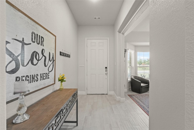 3409 Melrose Ct, Wylie, TX 75098 - foyer with light wood-type flooring, a textured wall, and baseboards