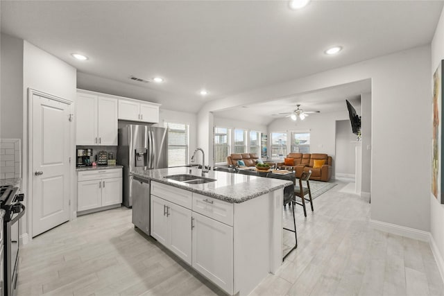 3409 Melrose Ct, Wylie, TX 75098 - kitchen with a sink, stainless steel appliances, light wood-style floors, white cabinetry, and tasteful backsplash