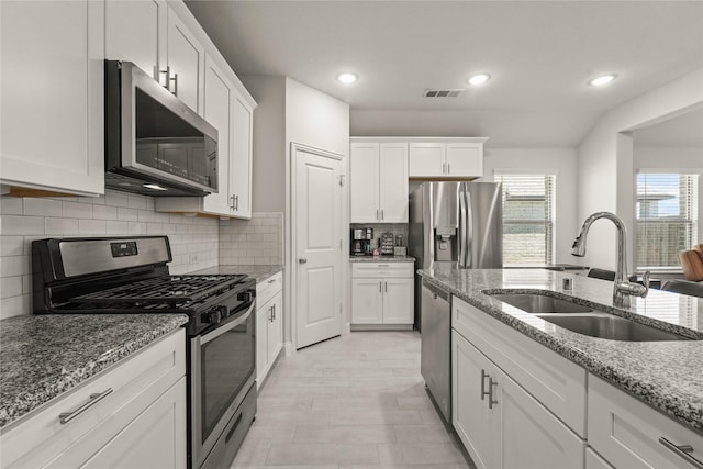 3409 Melrose Ct, Wylie, TX 75098 - kitchen with stainless steel appliances, a sink, white cabinetry, light stone counters, and recessed lighting