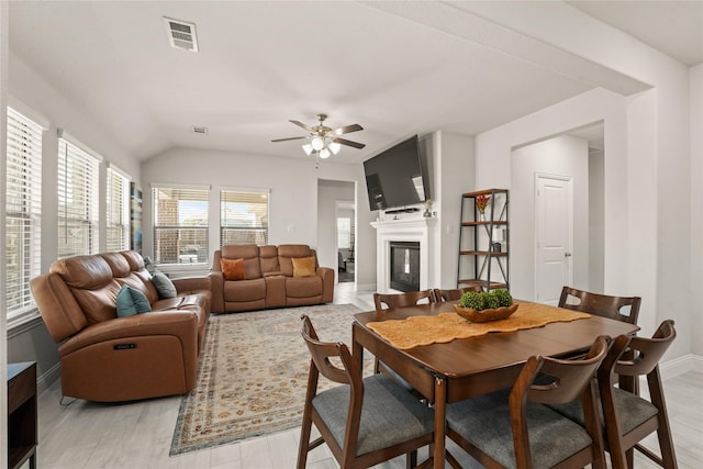 3409 Melrose Ct, Wylie, TX 75098 - dining room featuring a ceiling fan, baseboards, a glass covered fireplace, lofted ceiling, and light wood finished floors