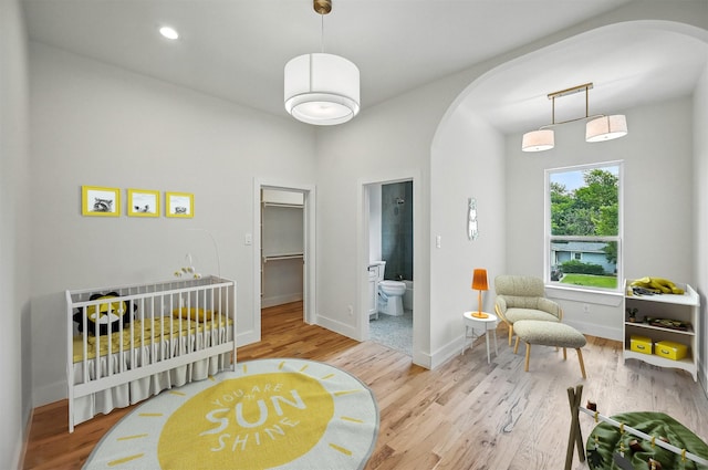 1224 S Pine St, Grapevine, TX 76051 - bedroom with arched walkways, wood finished floors, baseboards, and ensuite bath