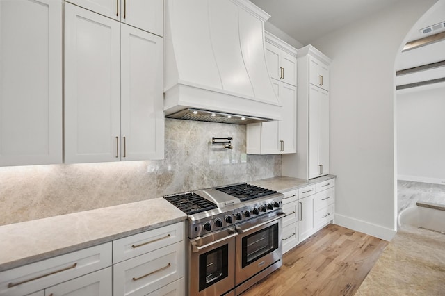 1224 S Pine St, Grapevine, TX 76051 - kitchen with double oven range, custom exhaust hood, white cabinetry, baseboards, and light wood finished floors