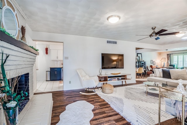 10542 Vinemont St, Dallas, TX 75218 - living area featuring wood finished floors, a ceiling fan, a fireplace, and baseboards