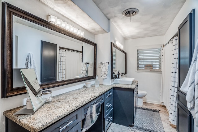 10542 Vinemont St, Dallas, TX 75218 - full bath featuring double vanity, toilet, and tile patterned floors