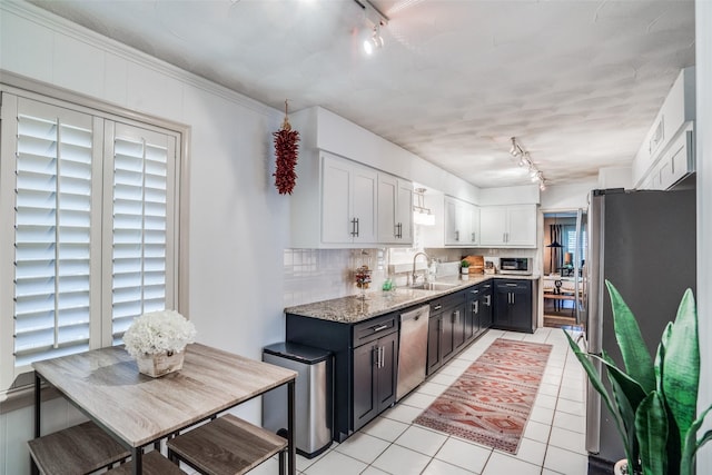 10542 Vinemont St, Dallas, TX 75218 - kitchen featuring track lighting, stainless steel appliances, backsplash, and white cabinetry