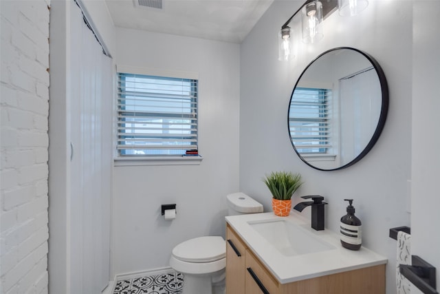 10542 Vinemont St, Dallas, TX 75218 - bathroom with vanity, toilet, and baseboards