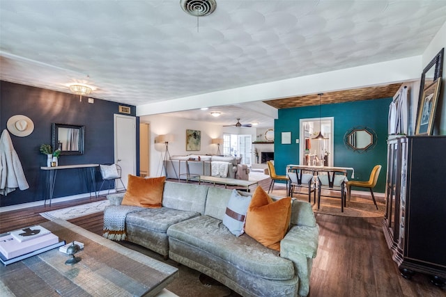 10542 Vinemont St, Dallas, TX 75218 - living room with dark wood-type flooring, baseboards, a fireplace, and a ceiling fan