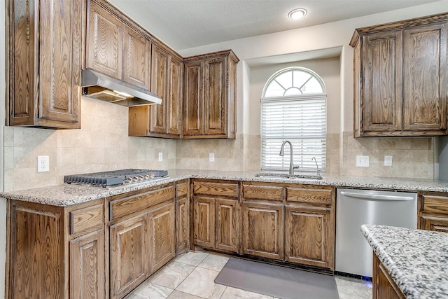9836 Amaranth Dr, Fort Worth, TX 76177 - kitchen with appliances with stainless steel finishes, a sink, under cabinet range hood, tasteful backsplash, and light stone counters