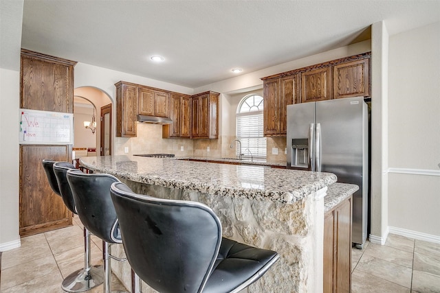 9836 Amaranth Dr, Fort Worth, TX 76177 - kitchen featuring stainless steel fridge with ice dispenser, under cabinet range hood, a sink, a kitchen island, and backsplash
