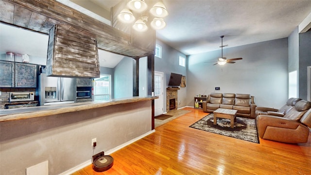 7409 Pebble Beach Dr, Rowlett, TX 75088 - living room with a fireplace, ceiling fan, wood finished floors, baseboards, and lofted ceiling