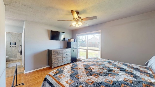 7409 Pebble Beach Dr, Rowlett, TX 75088 - bedroom featuring wood finished floors, a textured ceiling, baseboards, ensuite bath, and a ceiling fan