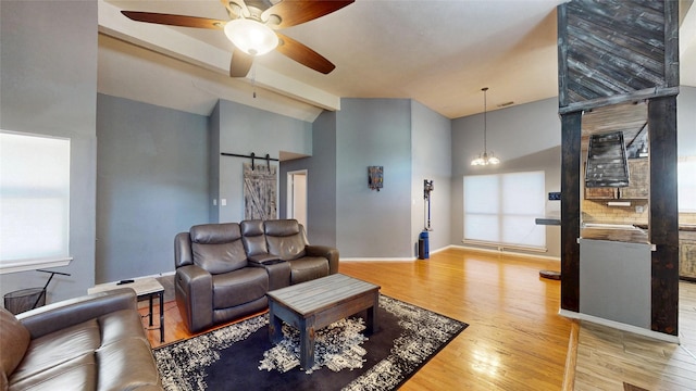 7409 Pebble Beach Dr, Rowlett, TX 75088 - living room featuring light wood-style flooring, a barn door, a ceiling fan, high vaulted ceiling, and baseboards