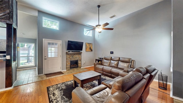7409 Pebble Beach Dr, Rowlett, TX 75088 - living room with plenty of natural light, a ceiling fan, hardwood / wood-style floors, a stone fireplace, and high vaulted ceiling