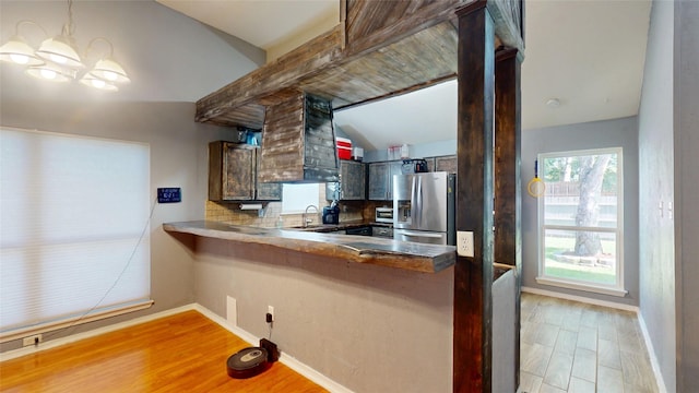 7409 Pebble Beach Dr, Rowlett, TX 75088 - kitchen featuring stainless steel fridge with ice dispenser, decorative backsplash, baseboards, light wood-type flooring, and custom exhaust hood