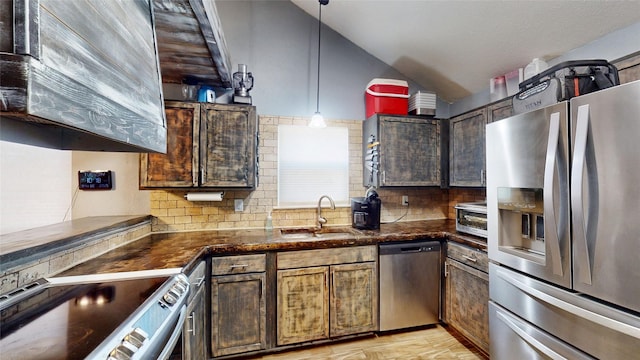 7409 Pebble Beach Dr, Rowlett, TX 75088 - kitchen featuring stainless steel appliances, a sink, backsplash, lofted ceiling, and hanging light fixtures