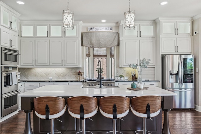 5594 Beacon Hill Dr, Frisco, TX 75036 - kitchen with stainless steel appliances, white cabinetry, a kitchen breakfast bar, tasteful backsplash, and recessed lighting