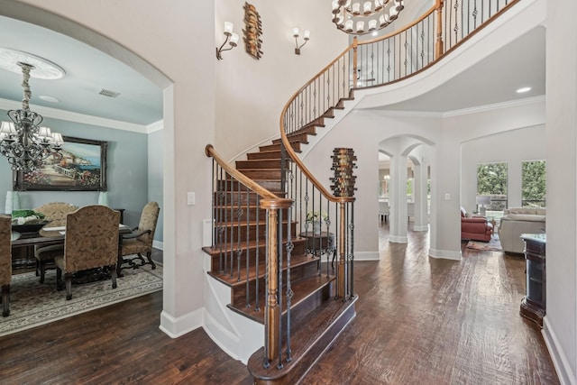 5594 Beacon Hill Dr, Frisco, TX 75036 - stairs with arched walkways, a chandelier, ornamental molding, wood finished floors, and a towering ceiling