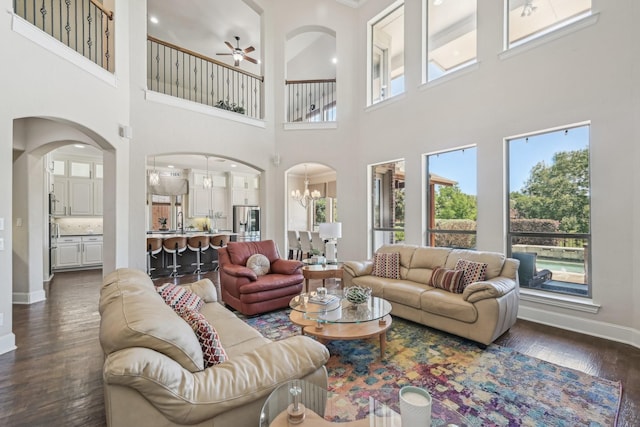 5594 Beacon Hill Dr, Frisco, TX 75036 - living area with ceiling fan, a towering ceiling, dark wood-style floors, baseboards, and arched walkways