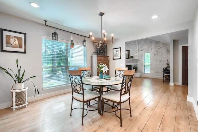 9613 County Road 4091, Scurry, TX 75158 - dining area featuring baseboards, light wood finished floors, a chandelier, brick wall, and a fireplace