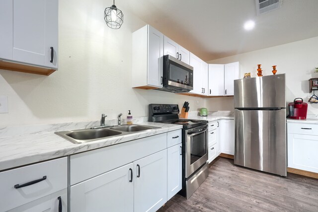 9613 County Road 4091, Scurry, TX 75158 - kitchen with appliances with stainless steel finishes, a sink, wood finished floors, and white cabinetry
