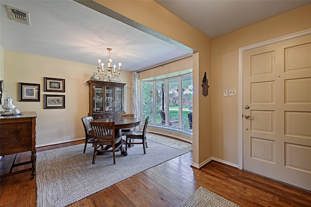 2112 Columbia Dr, Richardson, TX 75081 - dining area with a chandelier, dark wood-style flooring, and baseboards