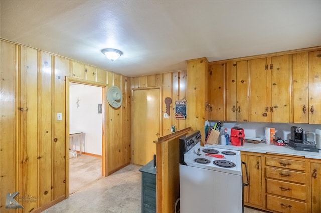 2757 Old Anson Rd, Abilene, TX 79603 - kitchen with white electric range, light countertops, light carpet, brown cabinetry, and wooden walls