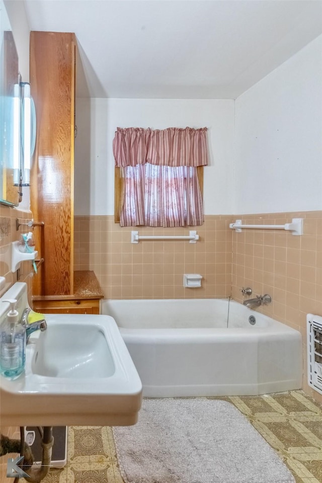 2757 Old Anson Rd, Abilene, TX 79603 - full bath featuring tile walls, a garden tub, a sink, heating unit, and wainscoting